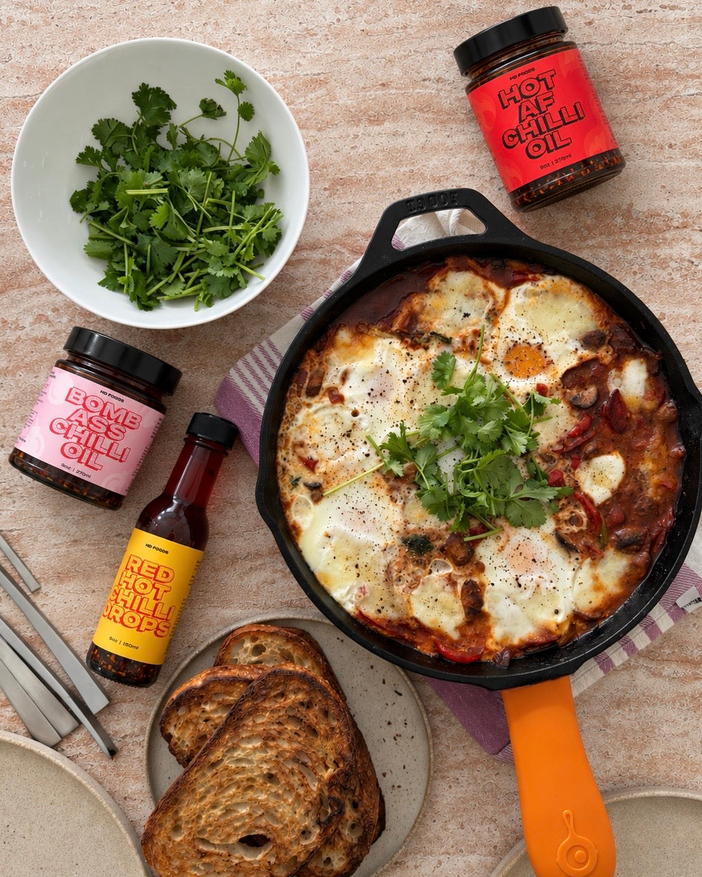 Shakshuka in a cast-iron pan with BACO, hotAF and Red Hot Chilli Drops, the Ring Sting Trio